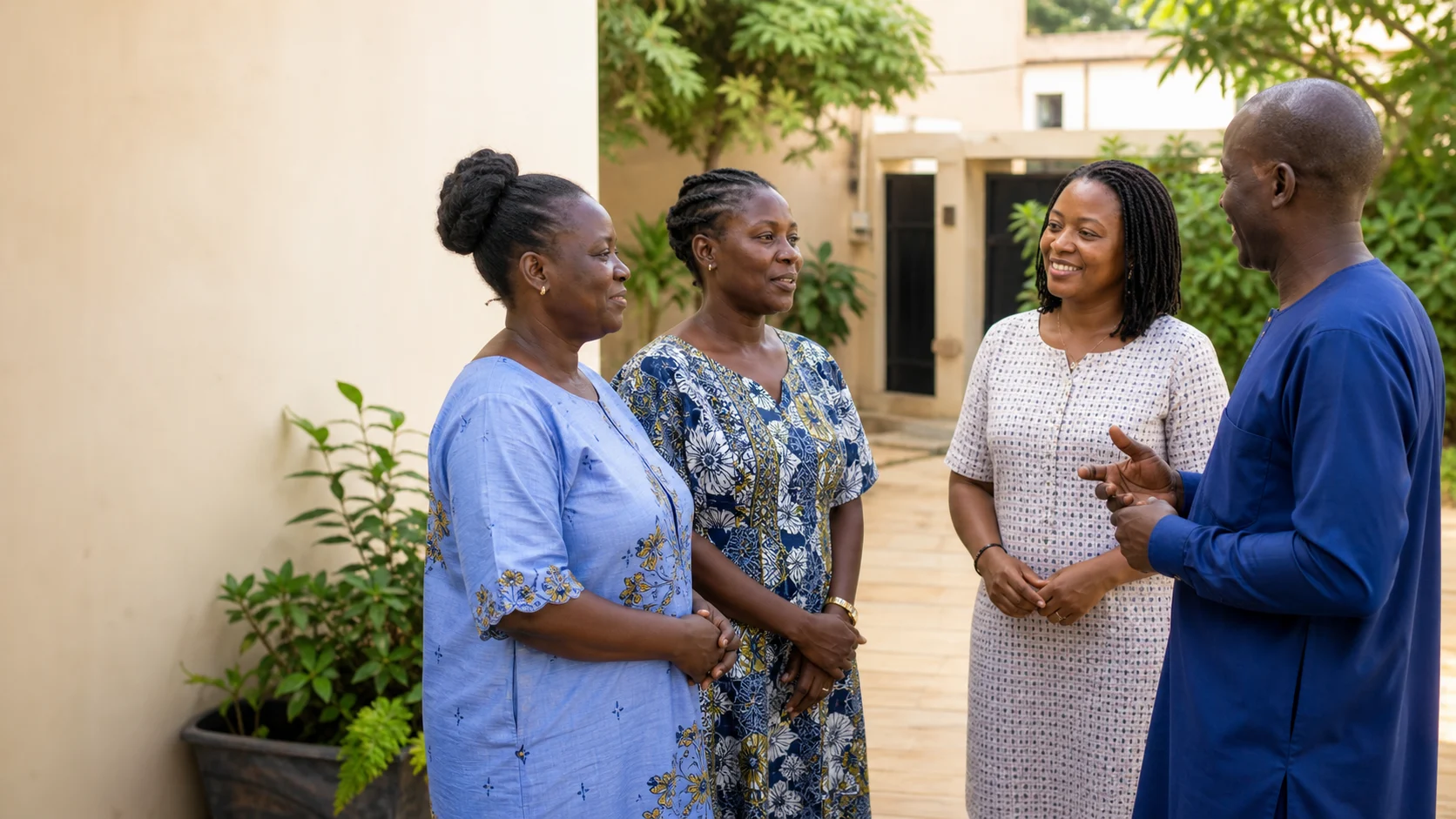 Des représentants et des travailleuses échangent dans une cour au Bénin